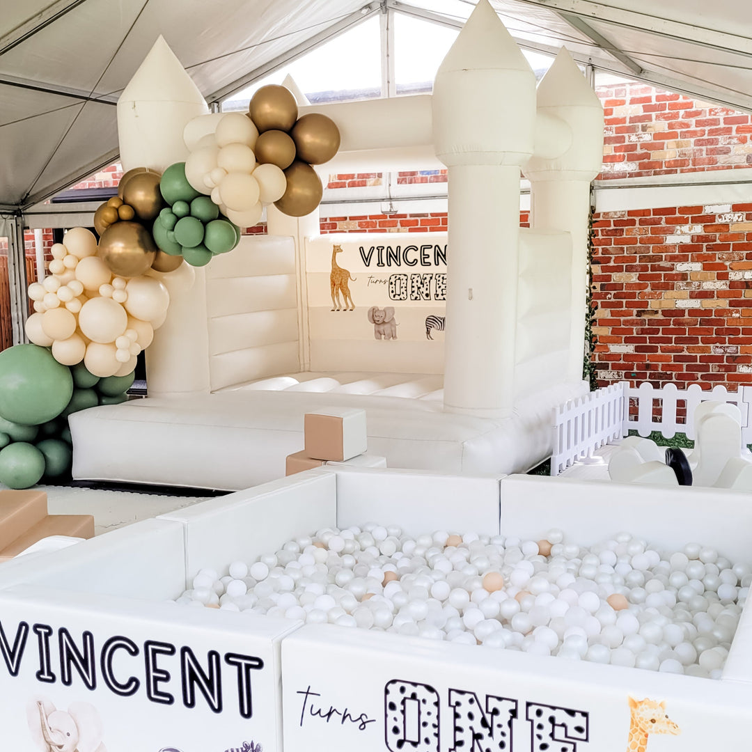Olaf luxe white ball pit with a safari themed Vincent turns one decal in a marquee, white castle with sage garland behind