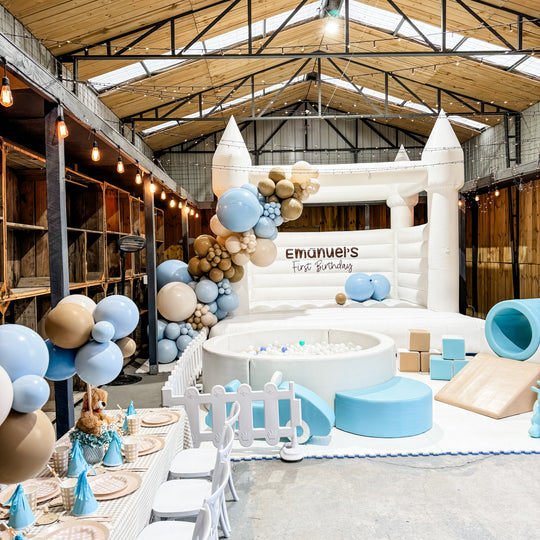 Emanuel balloon garland in pale blue, tan and cream on a white bouncy castle at a warehouse party for party hire in Melbourne