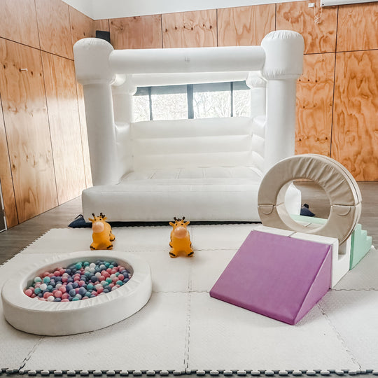 Mini Luxe package with a white bouncy castle, ball pit, ring tunnel slide and giraffe hoppers for party hire in Melbourne