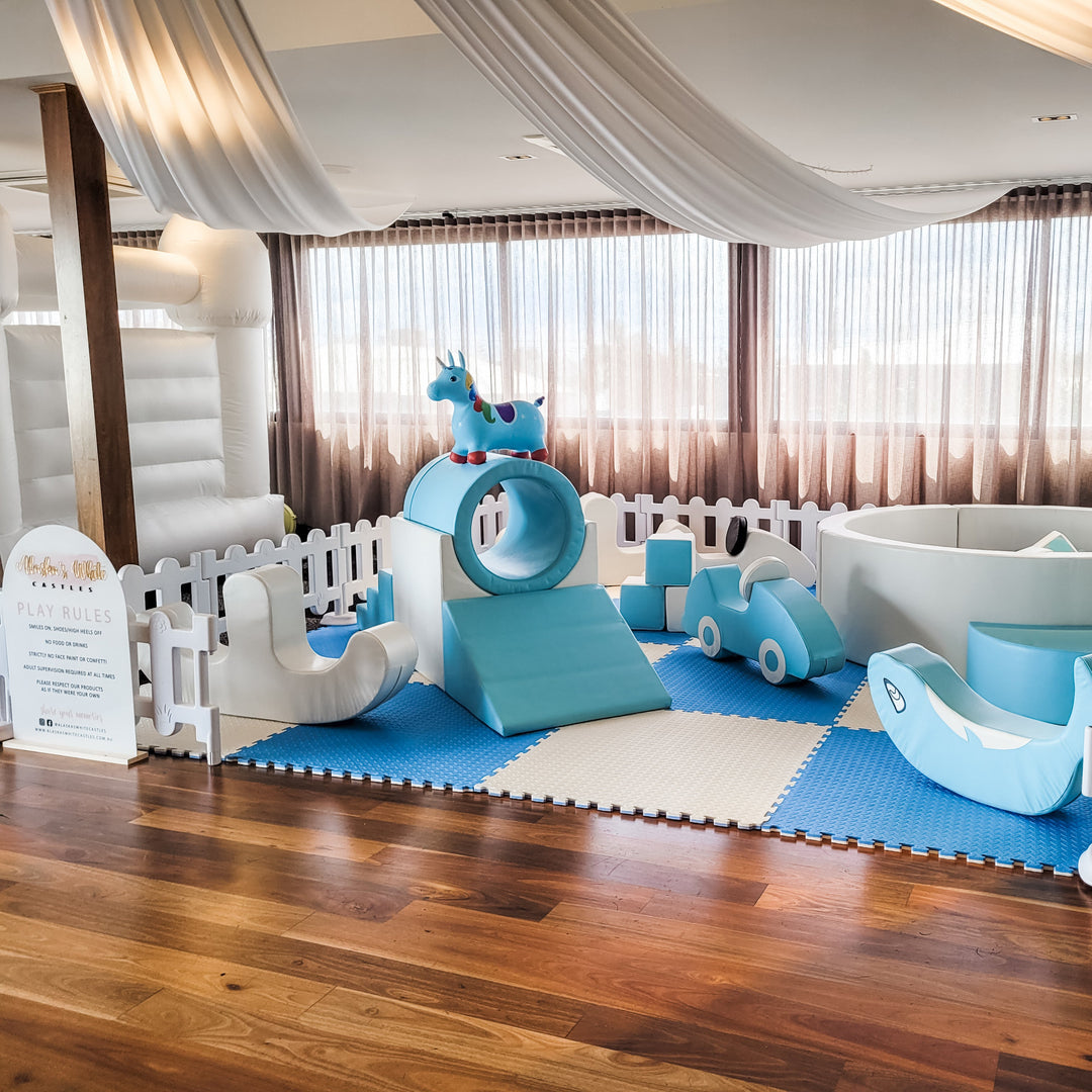 Unicorn hopper on the baby blue ring tunnel, with a foam car, dolphin rocker and ball pit on a timber floor by a Play Rules sign